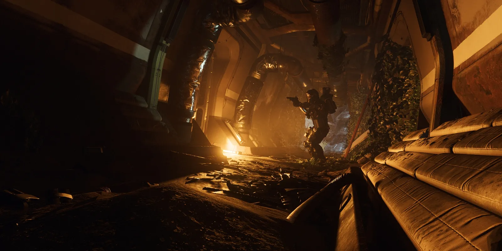 Official Star Citizen screenshot of an armored player aiming a pistol down a dark, overgrown ship corridor lit by a warm orange glow